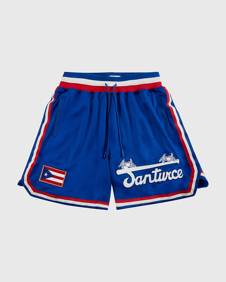 The Ebbets Field Santurce Cangrejeros Mesh Shorts feature blue mesh, red and white stripes, a drawstring waist, the Puerto Rican flag on one leg, and “Santurce” with winged horse logos on the other—a true tribute to Santurce baseball.