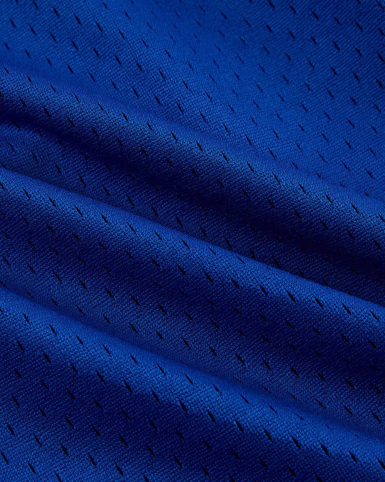Close-up of blue mesh fabric with a diagonal pattern and mini perforations, highlighting the texture of Ebbets Field Santurce Cangrejeros Mesh Shorts—ideal for fans of Puerto Rican baseball legends.