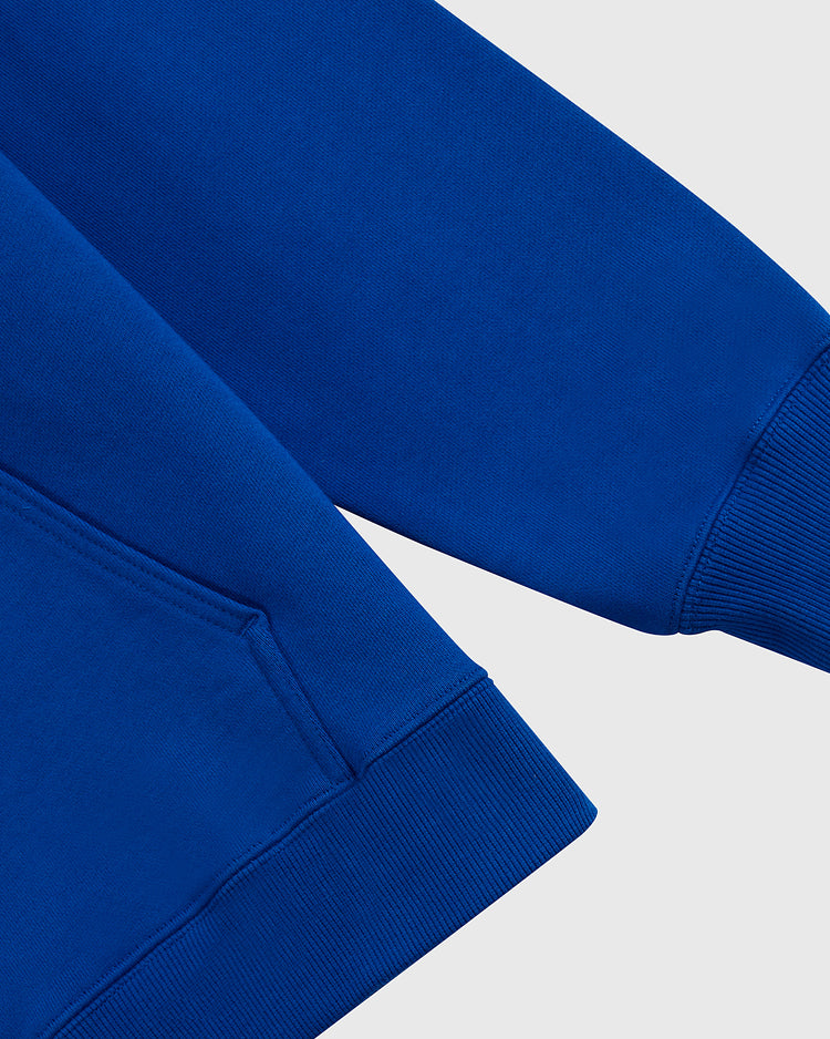 Close-up of the Santurce Cangrejeros Heavyweight Cotton Pullover Hoodie by Ebbets Field, highlighting the ribbed cuff, hem, and front pocket corner against a light grey background—ideal for Puerto Rican baseball fans.