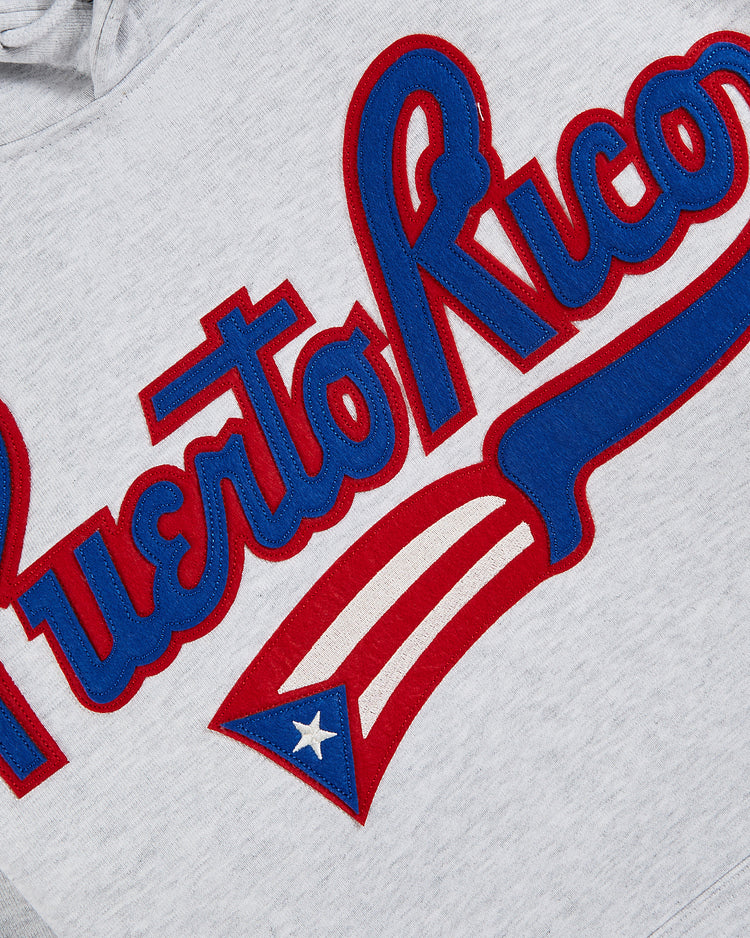 The Ebbets Field Puerto Rico 1972 National Team Heavyweight Cotton Terry Pullover Hoodie features gray French terry, bold red and blue “Puerto Rico” embroidery, and a stylized flag—ideal for fans of the national team.