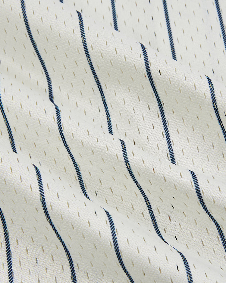 Close-up of the New York Cubans Mesh Button-Up Jersey by Ebbets Field, featuring white fabric with thin vertical blue stripes and small perforations, echoing the classic textured style of Cuban baseball jerseys from the Negro Leagues.