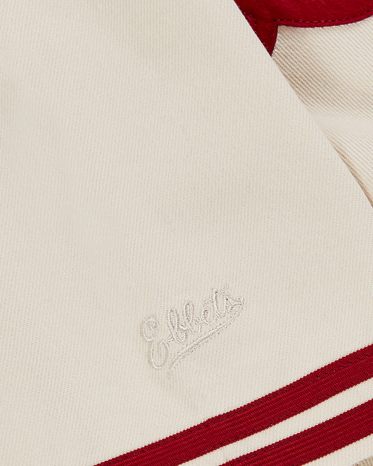A close-up of the Ebbets Field Pittsburgh Crawfords 1933 Cotton Twill Jersey shows cream fabric with red trim and embroidery. 