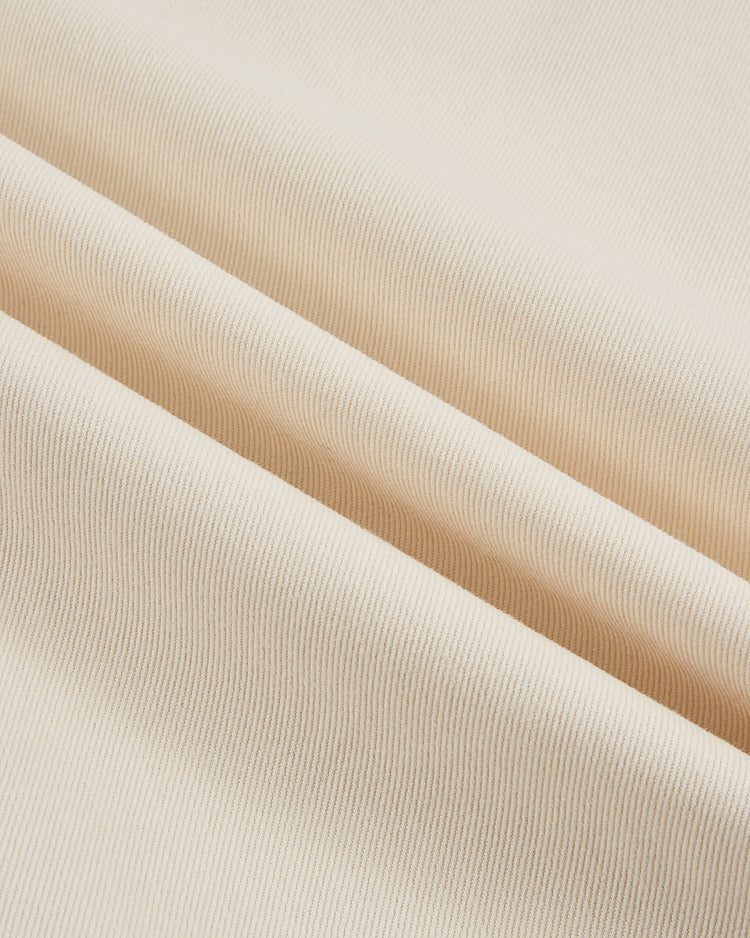 Close-up of light beige ribbed cotton twill fabric with soft diagonal folds, as seen in the Ebbets Field Pittsburgh Crawfords 1933 Jersey—echoing the fine texture and lines of vintage baseball apparel.