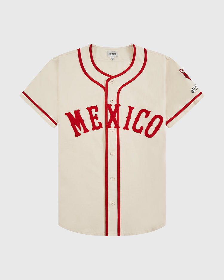 The Ebbets Field Diablos Rojos del Mexico Cotton Twill Baseball Jersey features a cream color, red trim and buttons, bold red “MEXICO” lettering, a left sleeve patch, and celebrates Diablos Rojos de México heritage.
