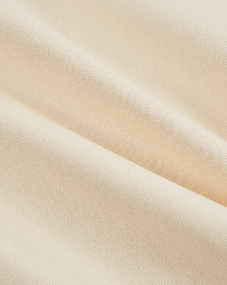 Close-up of the Diablos Rojos del Mexico Cotton Twill Baseball Jersey by Ebbets Field, featuring soft, cream-colored cotton twill with a ribbed texture and gentle diagonal folds, inspired by classic Mexican baseball style.