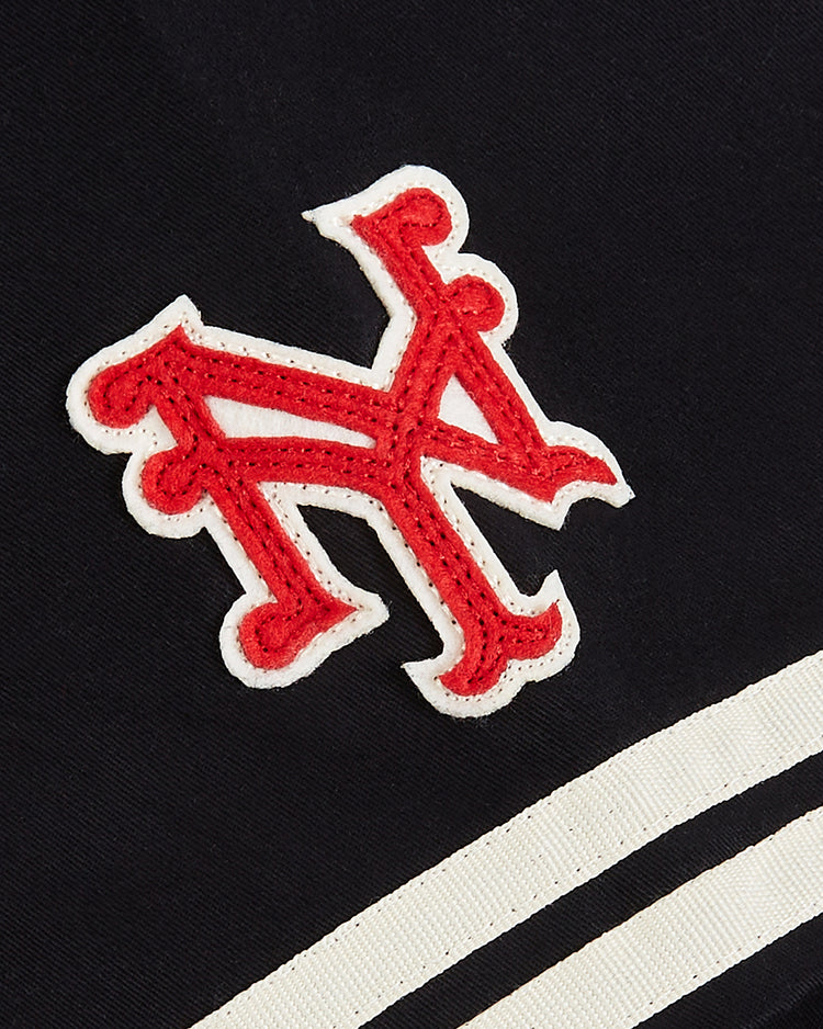 The Ebbets Field New York Cubans Cotton Twill Baseball Jersey features a red and white embroidered letter N on dark fabric with two white stripes, echoing the classic Negro League style worn by legendary Cuban players.