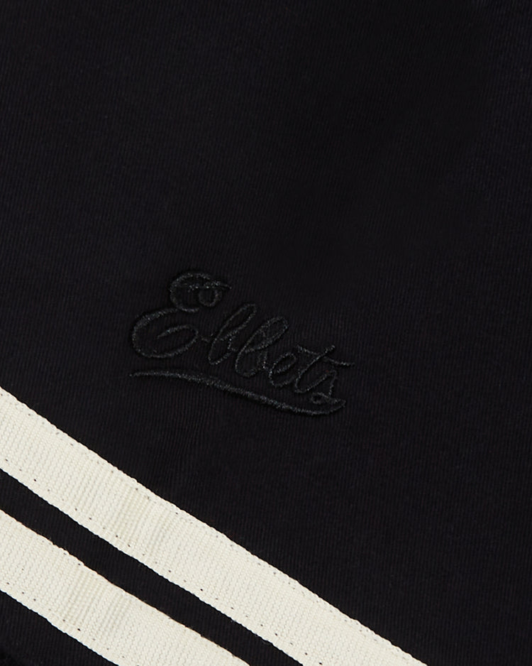 Close-up of the New York Cubans Cotton Twill Baseball Jersey by Ebbets Field, featuring black embroidery inspired by Cuban baseball legends and two diagonal white stripes on the lower black fabric.