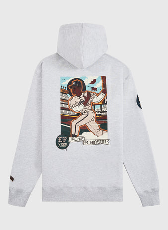 The Ebbets Field Karabo Poppy x Jackie Robinson Heavyweight Cotton Pullover Hoodie features a light gray design with vibrant Jackie Robinson artwork, stadium backdrop, and “Jackie Robinson” text—created for Black History Month with a black patch on the left sleeve.