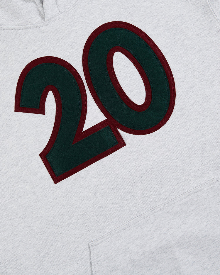 A close-up of the Ebbets Field Karabo Poppy x Ebbets Field Josh Gibson Heavyweight Cotton Pullover Hoodie in light gray, featuring a bold dark green 20 outlined in maroon on the chest and a visible front pocket—a tribute to the Negro Leagues.