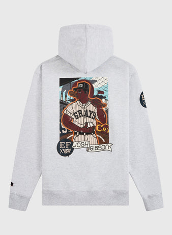 The Ebbets Field Karabo Poppy x Josh Gibson Heavyweight Cotton Pullover Hoodie features a light gray design with an illustrated Josh Gibson in pinstripes, team logos on the sleeves, and vibrant “Josh Gibson” text.