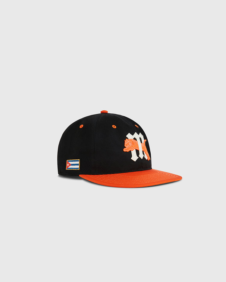 The Marianao Tigres Cotton Twill Ballcap by Ebbets Field features a black crown, orange brim, embroidered white “M” with orange tiger front logo, and a Cuban flag patch on the side—authentic style from the Cuban League.