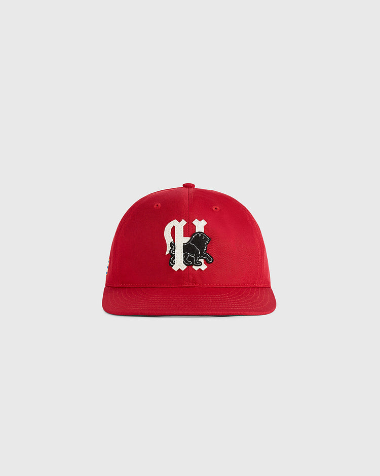 The Habana Leones Cotton Twill Ballcap by Ebbets Field, featuring a red cotton twill design and a black-and-white gothic C with a lion, is centered on a plain light gray background.