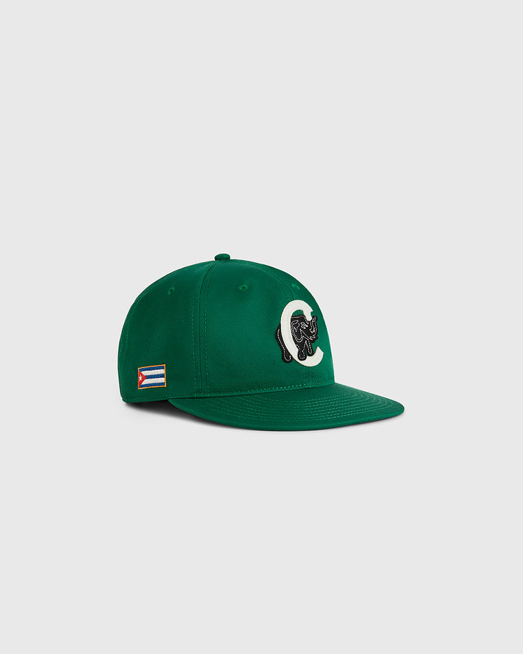 The Ebbets Field Cienfuegos Elefantes Cotton Twill Ballcap is green with a curved brim, a black and white elephant logo on the front, and a small Cuban flag patch on the side. Shown against a plain light gray background.