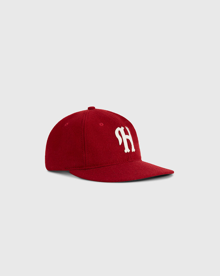 The Ebbets Field Habana Leones Cuba 1940 Authentic Wool Ballcap features a red vintage design with a curved brim and white SH lettering, inspired by the classic team cap and shown against a plain light gray background.