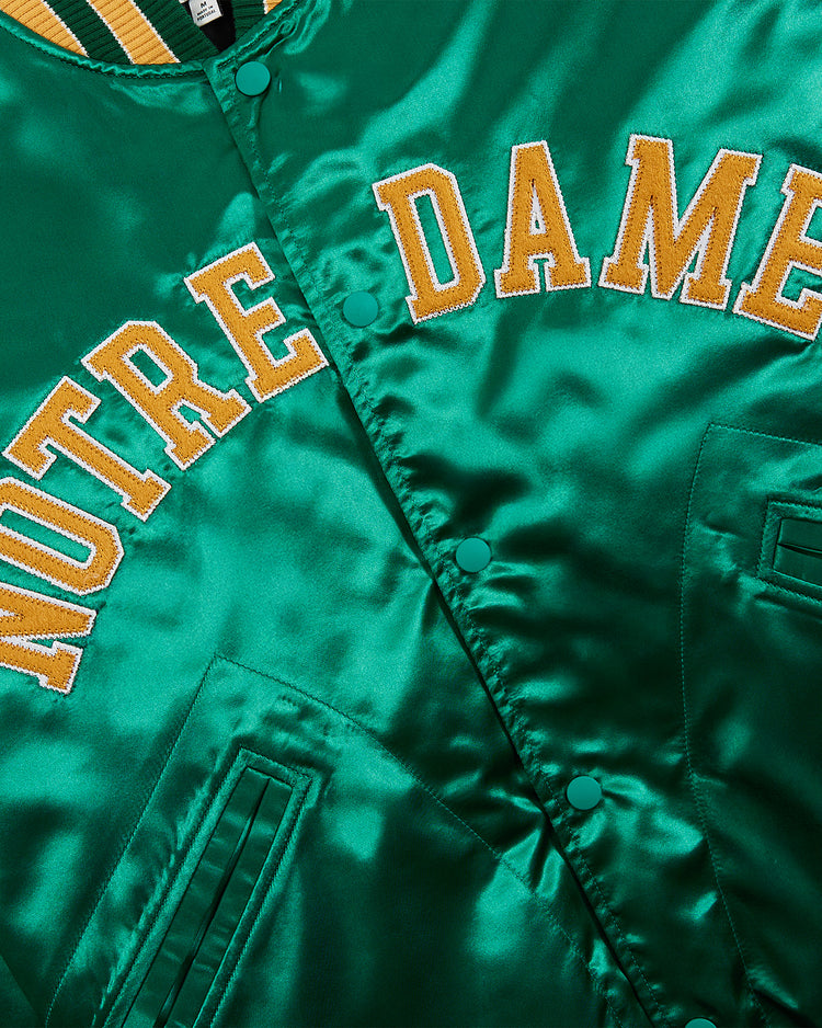 Close-up of the Ebbets Field Notre Dame Satin Varsity Jacket, featuring shiny green satin, yellow and white 