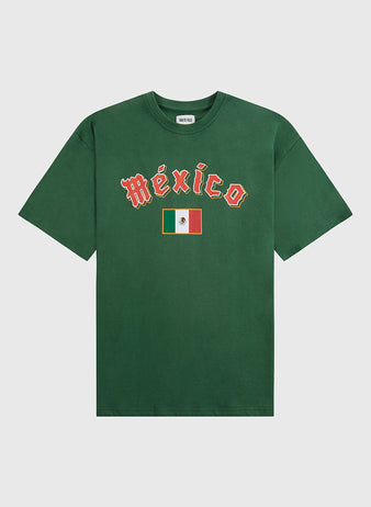 The Ebbets Field Mexico National Team Short Sleeve Graphic Tee is a green vintage shirt with “México” in white and red letters above the Mexican flag on the chest, inspired by the national baseball team and shown against a plain white background.