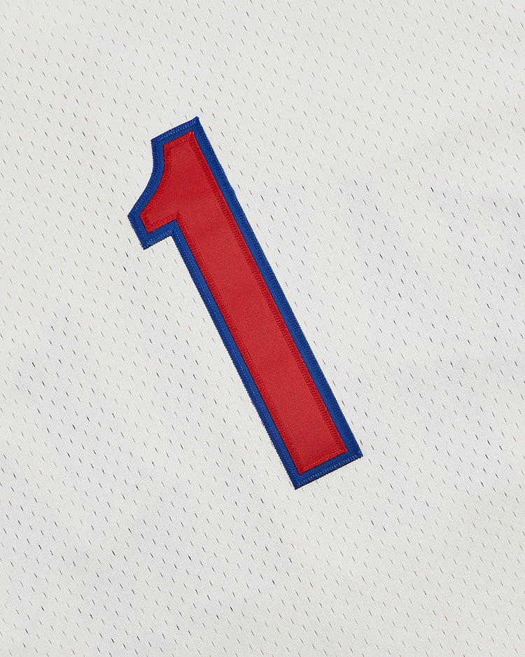 A close-up of a red number one outlined in blue on the white perforated mesh fabric of the Ebbets Field Havana Cubans Mesh Button-Up Jersey, capturing vintage minor league baseball style.