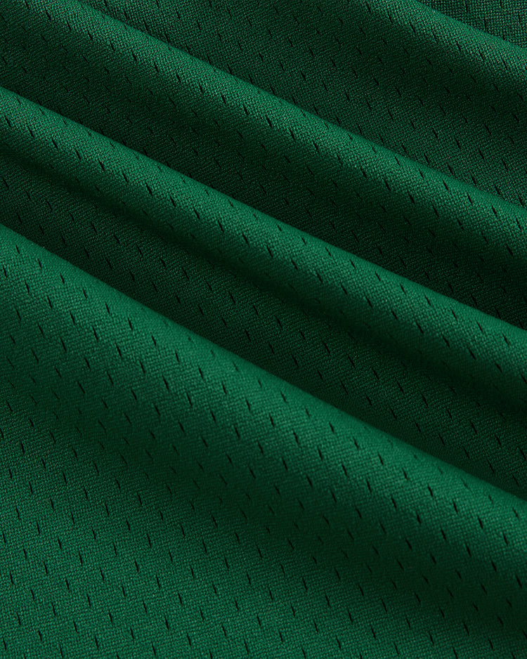 Close-up of the Guinness Toucan Mesh V-Neck Jersey by Ebbets Field, showing green athletic mesh fabric with small perforations and diagonal folds that emphasize its breathable texture.