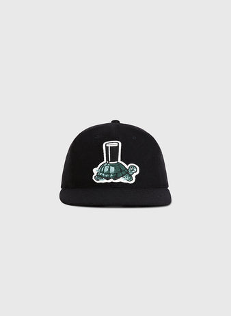 The Ebbets Field Guinness Turtle Authentic Wool Ballcap features a black design with an embroidered green turtle carrying a tall glass, shown on a plain light gray background.