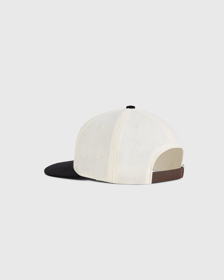 The Guinness Flying Toucan Authentic Wool Ballcap by Ebbets Field features a white crown, black brim, adjustable brown strap at the back, and a small black button on top, shown from the rear.
