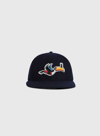 The Guinness Flying Toucan Authentic Wool Ballcap by Ebbets Field is a navy blue cap featuring a colorful embroidered toucan on the front, displayed against a plain light gray background.
