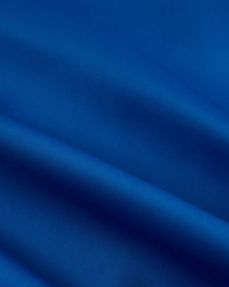 A close-up of smooth, vibrant blue satin with soft folds and shadows, inspired by the legendary Santurce Cangrejeros and featured in the Ebbets Field Santurce Cangrejeros Cotton Lined Satin Varsity Jacket.