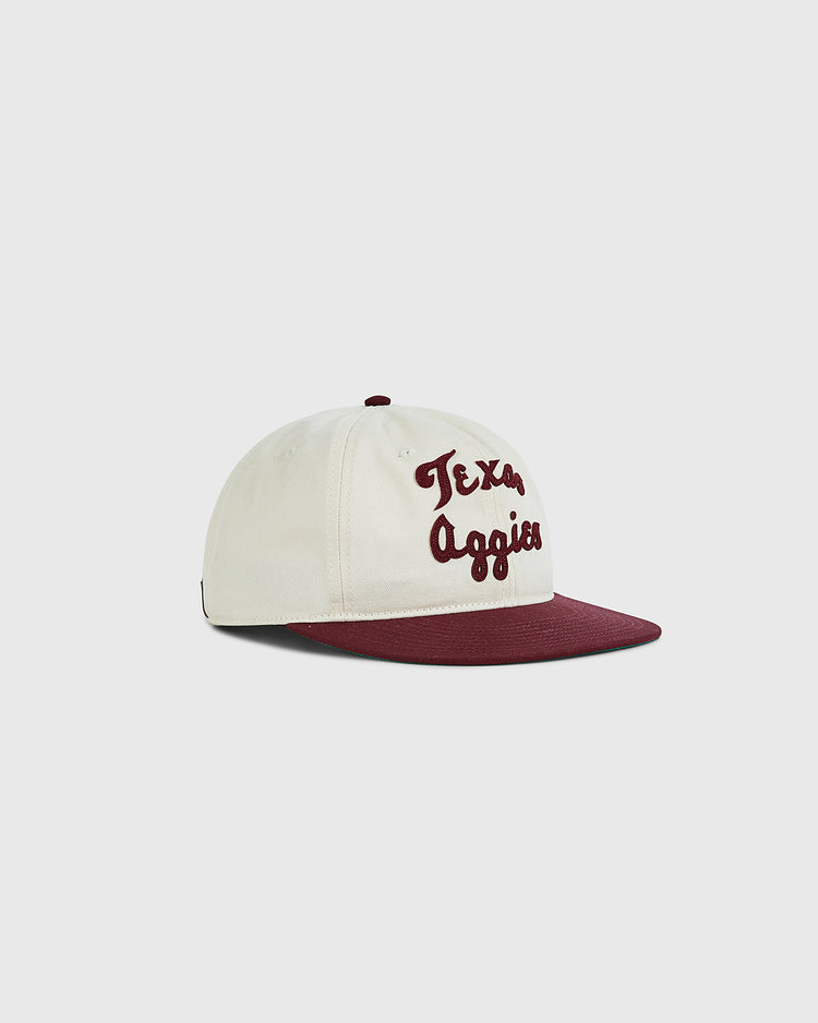The Ebbets Field Texas A&M University 1952 Cotton Twill Ballcap features a cream body, maroon brim and button, and “Texas Aggies” in maroon script—an essential vintage addition to any Aggies hat collection. Shown on a light background.