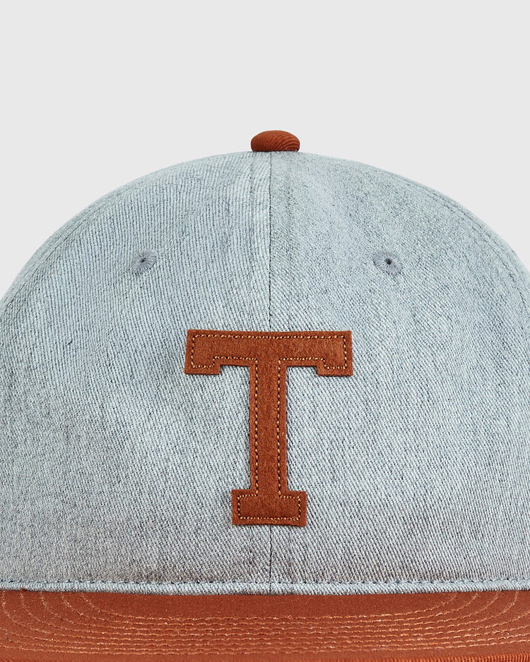 The Ebbets Field University of Texas 1943 Cotton Twill Ballcap features light denim, a brown brim, brown top button, and a brown stitched T on the front center, inspired by the iconic 1943 Texas Longhorns.