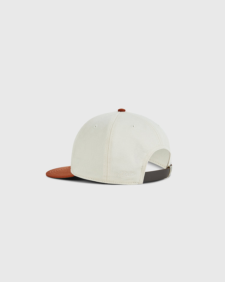 The Ebbets Field University of Texas 1975 Cotton Twill Ballcap features a cream cotton twill body, brown brim, adjustable strap, and a small brown top button—an homage to the Longhorns at the 1975 College World Series.