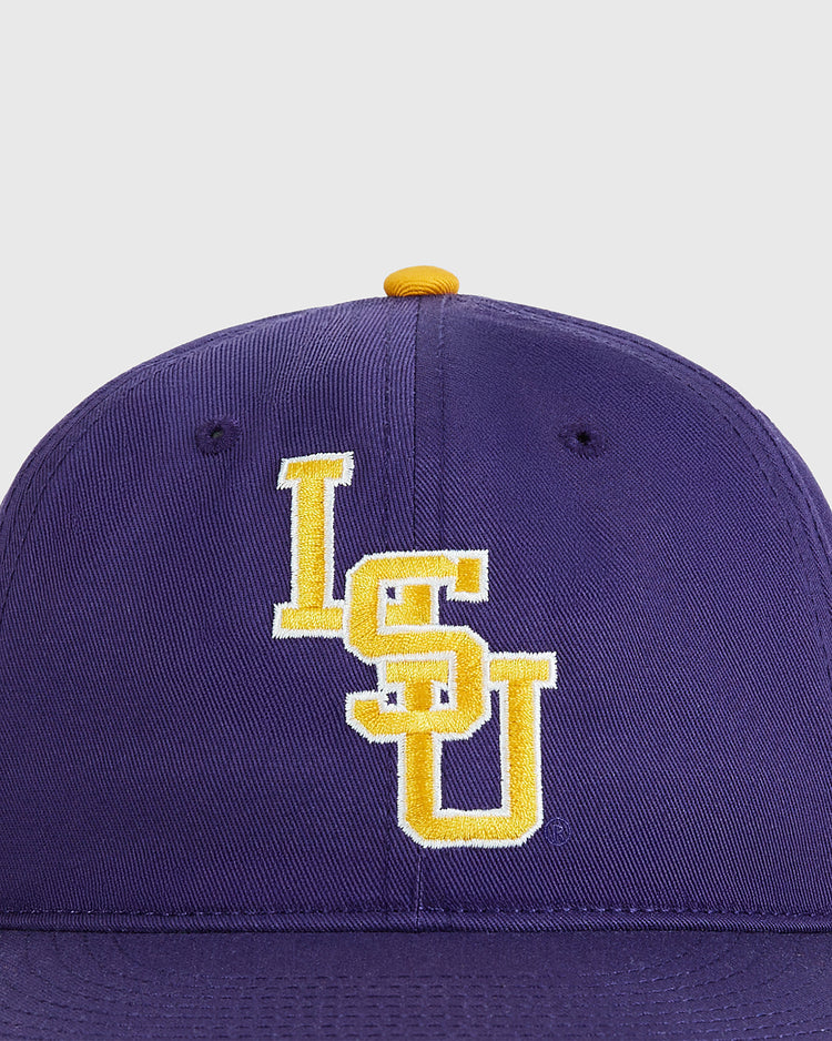 A close-up of the Ebbets Field Louisiana State University 1987 Cotton Twill Ballcap, a purple hat with yellow and white embroidered LSU letters on the front and a yellow button on top.