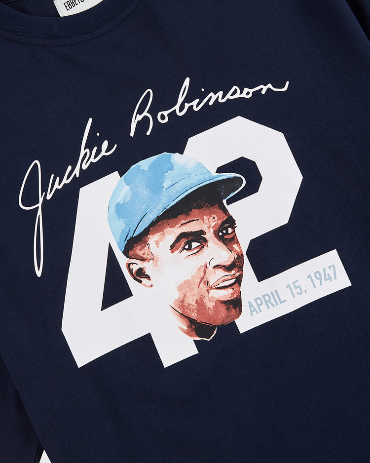 Celebrate the civil rights legend with the Ebbets Field Jackie Robinson Water Color Short Sleeve Graphic Tee, featuring a navy blue design, bold white 42, his portrait in a blue cap, signature, and April 15, 1947.