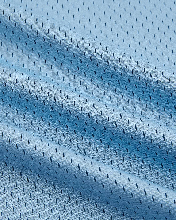Close-up of the Ebbets Field Jackie Robinson Powder Blue V-Neck Mesh Jersey, featuring soft powder blue mesh with small, evenly spaced perforations for breathability, reminiscent of classic styles and showcasing gentle folds in the fabric.