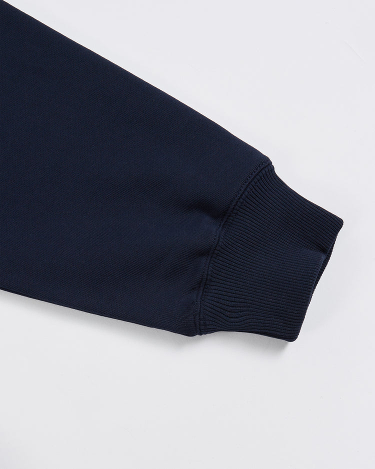 A close-up of the sleeve of the Ebbets Field Jackie Robinson All-Stars Heavyweight Cotton Terry Pullover Hoodie, in dark navy blue, highlights the ribbed cuff and part of the arm against a plain white background.