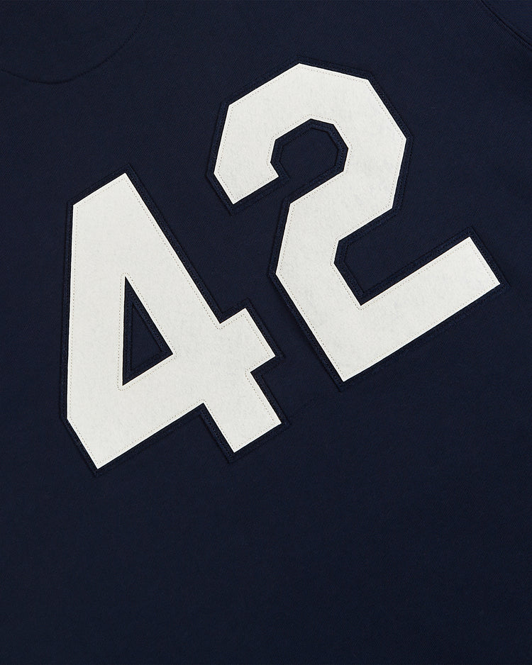 White block number 42 stands out on a dark blue background in the Ebbets Field Jackie Robinson All-Stars Heavyweight Cotton Terry Pullover Hoodie, inspired by the legendary player.