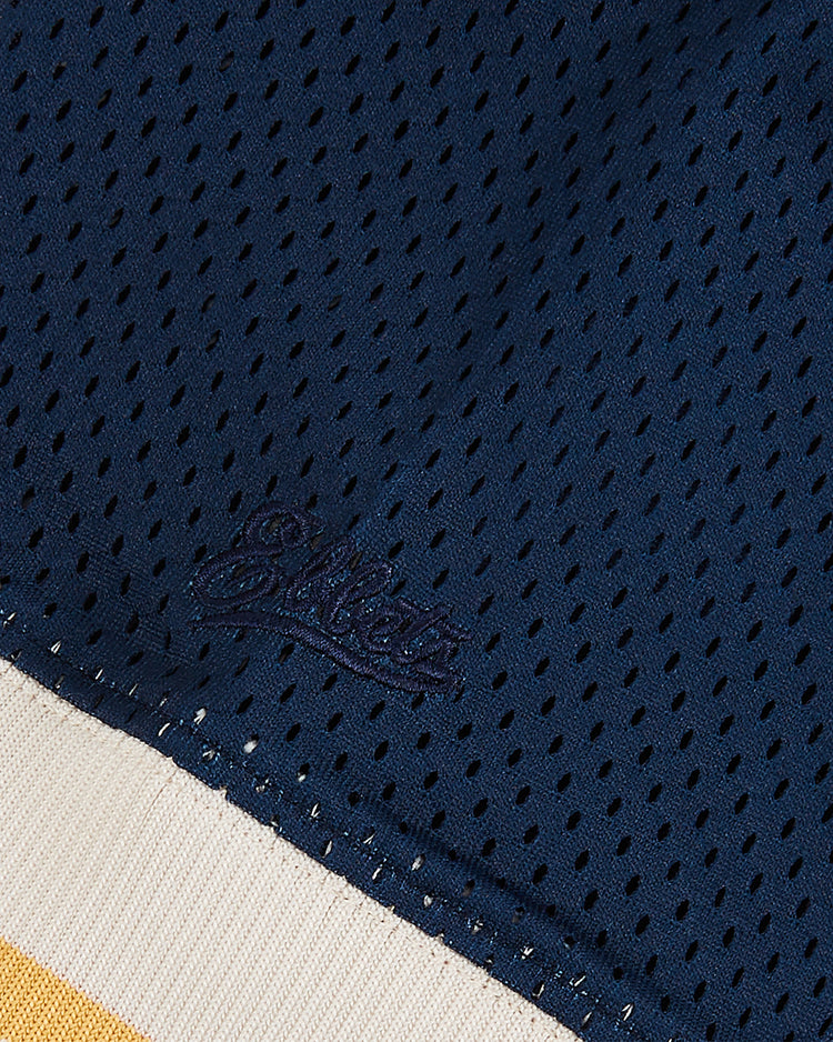 Close-up of the University of Notre Dame V-Neck Mesh Jersey by Ebbets Field, showing navy mesh fabric with embroidered 