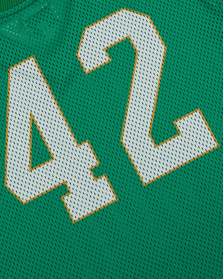 A close-up of the Ebbets Field University of Notre Dame V-Neck Mesh Jersey, featuring green mesh fabric with small holes, vintage baseball-inspired style, and large white and yellow-outlined number 42.