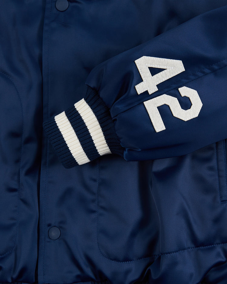 A close-up of the Ebbets Field Jackie Robinson Comic Book Hero Cotton Lined Satin Varsity Jacket in navy, featuring white striped ribbed cuffs and the number 42 on the sleeve.