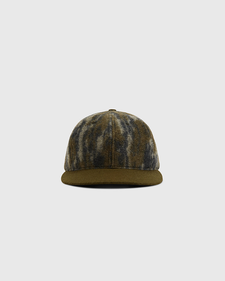 A front-facing view of the Ebbets Field Mossy Oak x Ebbets Field Blank Ballcap, featuring a Mossy Oak Bottomland camo pattern in green, brown, and gray, displayed against a plain light gray background.