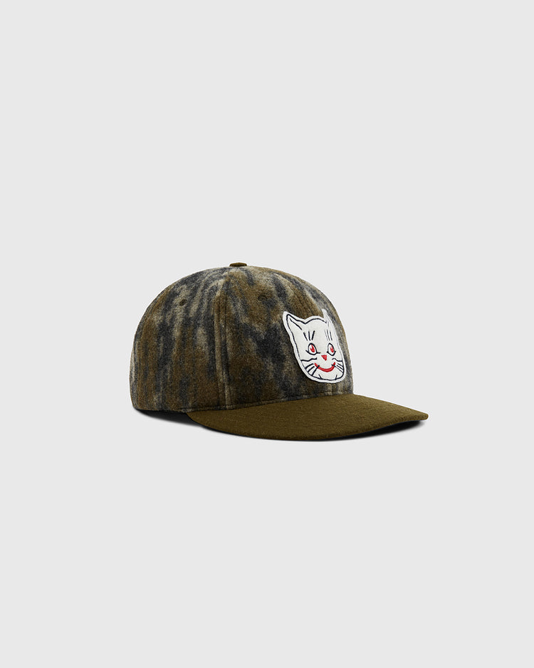 The Ebbets Field Mossy Oak x 1961 Kansas City Katz Ballcap features a mottled brown and gray pattern and an embroidered white cat face with red details on the front, shown against a plain light gray background.