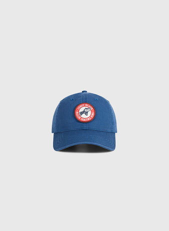 A washed cotton Coney Island Roller Skating Rink ballcap by Ebbets Field in blue, featuring a circular red and white patch on the front, set against a light gray background. Perfect for fans of Brooklyn style.