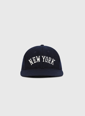 The Ebbets Field New York City Series Wool Ballcap features NEW YORK in white uppercase embroidery on navy wool broadcloth, shown against a plain light gray background.