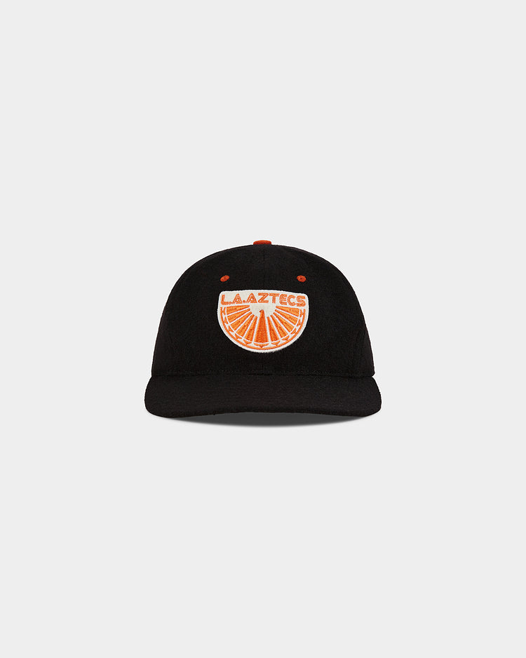 The Los Angeles Aztecs Wool Ballcap by Ebbets Field is a black cap with an orange and white embroidered patch on the front, displaying 