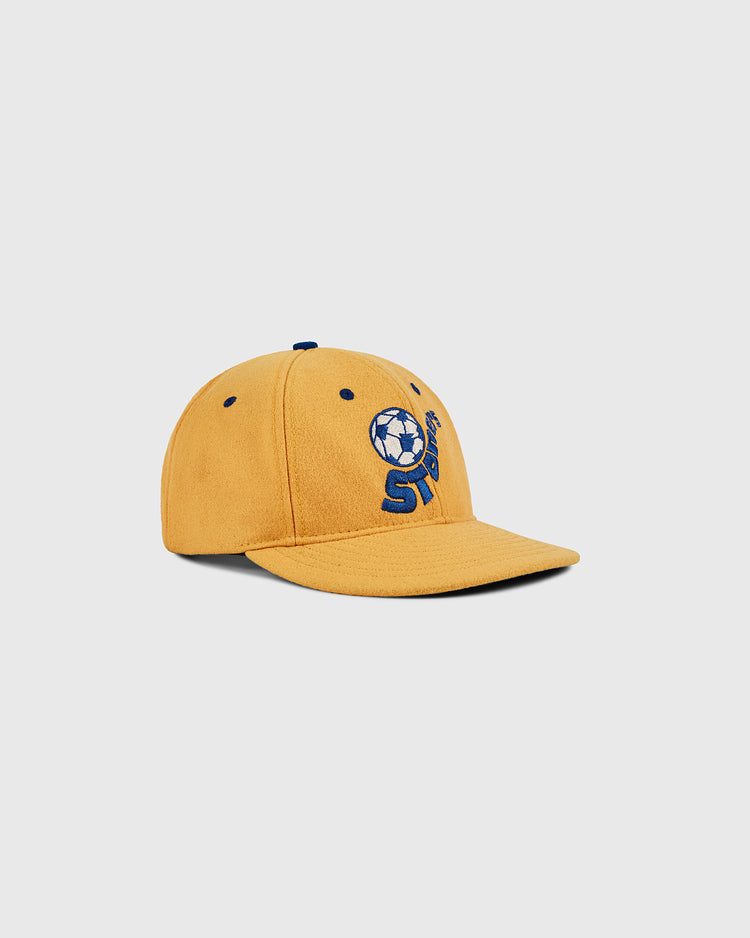 The Ebbets Field Pennsylvania Stoners Wool Ballcap features yellow wool, a blue soccer ball graphic, and “STAY” embroidered on the front, shown against a plain light gray background.