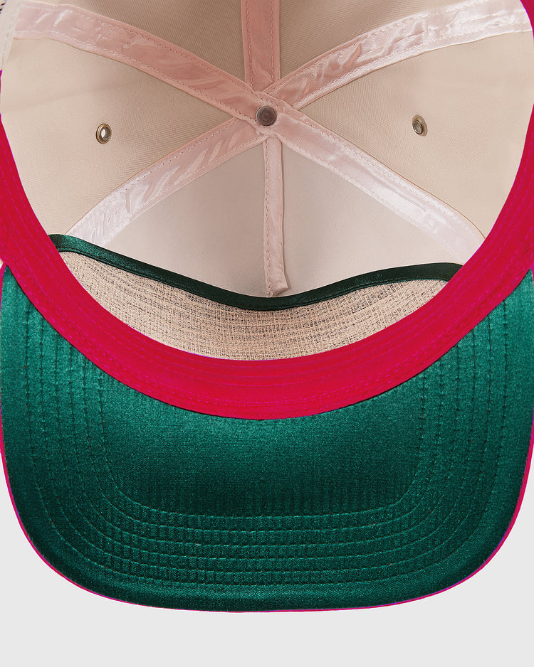 Close-up of the inside of the Ebbets Field Hawaii Islanders 1965 Logo A-Frame Cotton Twill Ballcap, highlighting its pink inner lining, metal eyelets for ventilation, and green bill with detailed stitching.