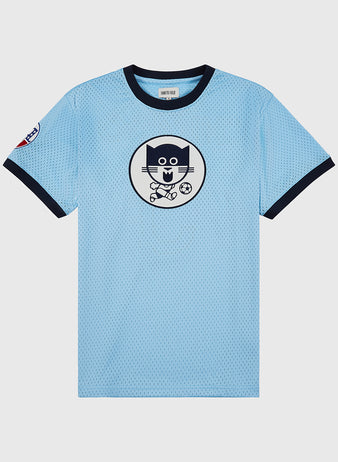 The Ebbets Field Chicago Cats Mesh Soccer Jersey is light blue with navy collar and sleeve trim, features a circle chest print of a cartoon cat playing soccer, inspired by classic Chicago Cats style, plus a small left sleeve patch.