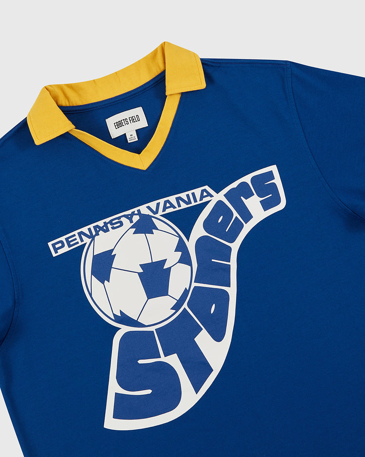 The Ebbets Field Pennsylvania Stoners Vintage Collar Soccer Jersey features a blue cotton build, yellow collar, and classic screen-printed team logo with a stylized soccer ball and bold white and blue text on the front.