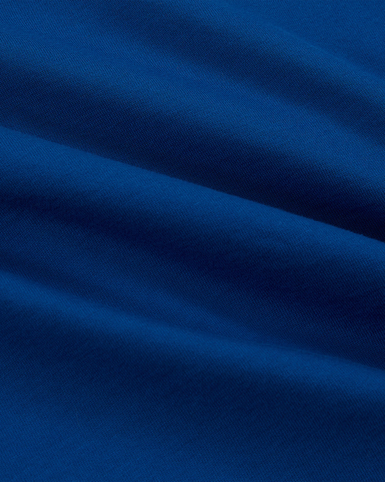 Close-up of the Pennsylvania Stoners Vintage Collar Soccer Jersey by Ebbets Field, featuring soft, blue cotton jersey fabric with gentle folds and shadows that highlight its smooth texture and rich color.
