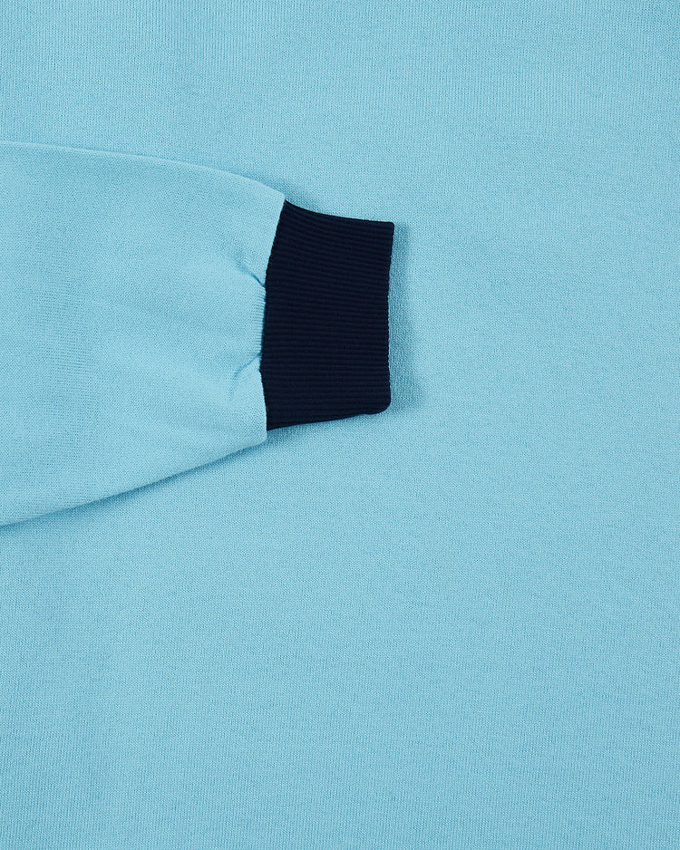 Close-up of the Ebbets Field Chicago Cats Vintage Soccer Goalie Jersey in light blue, featuring a black ribbed cuff and visible fabric texture, with part of the sleeve shown against a matching background.