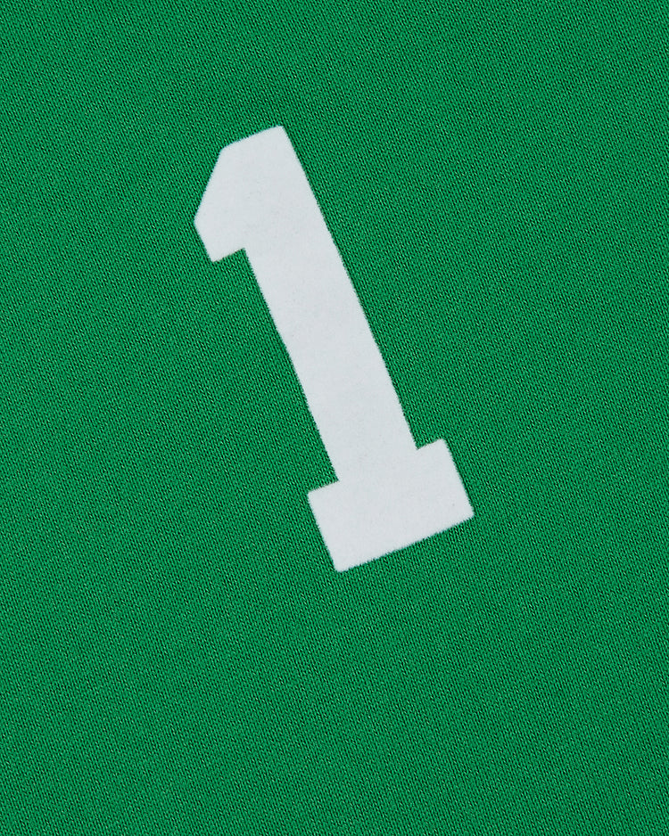A large white number one stands out on a green fabric background, capturing the classic look of the New York Cosmos Vintage Soccer Goalie Jersey by Ebbets Field.