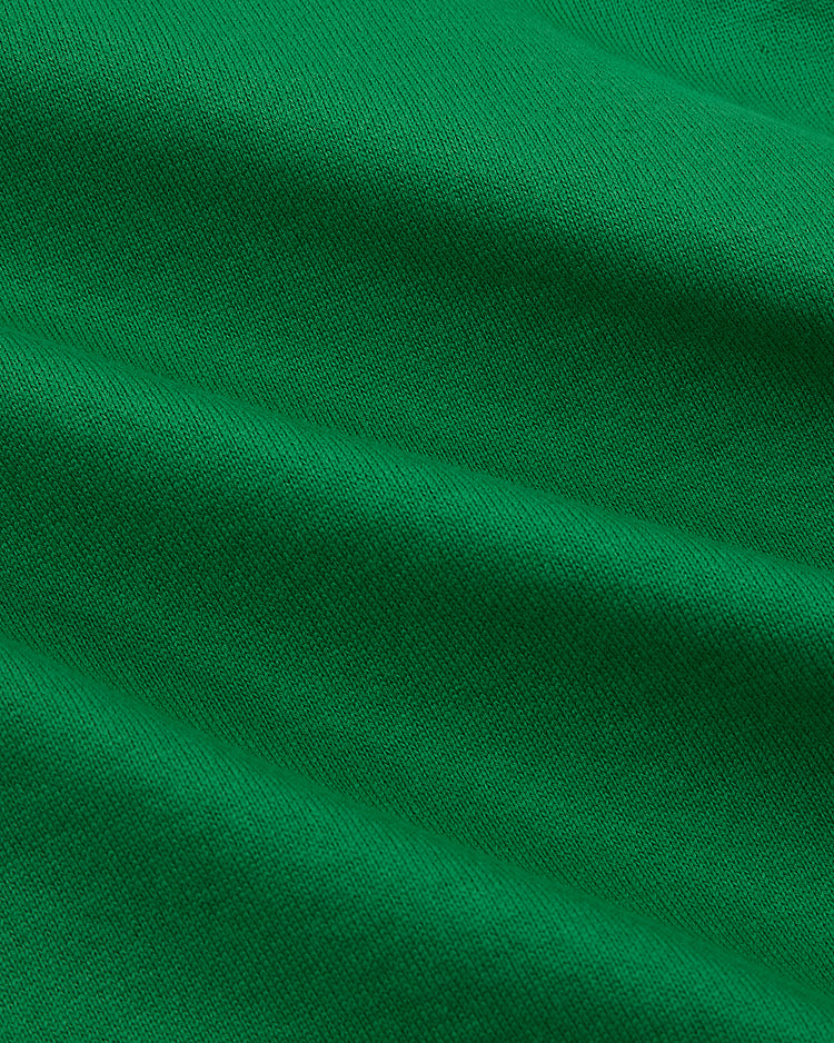 Close-up of green fabric with visible woven texture and gentle folds, reminiscent of the Ebbets Field New York Cosmos Vintage Soccer Goalie Jersey.